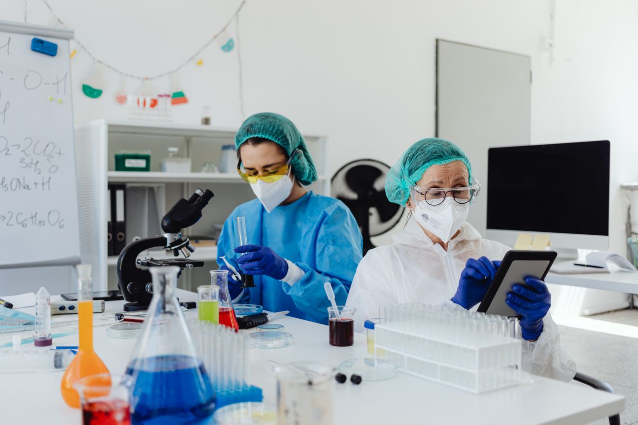 Services Researchers conducting experiments in a laboratory, using microscopes and digital tablets.